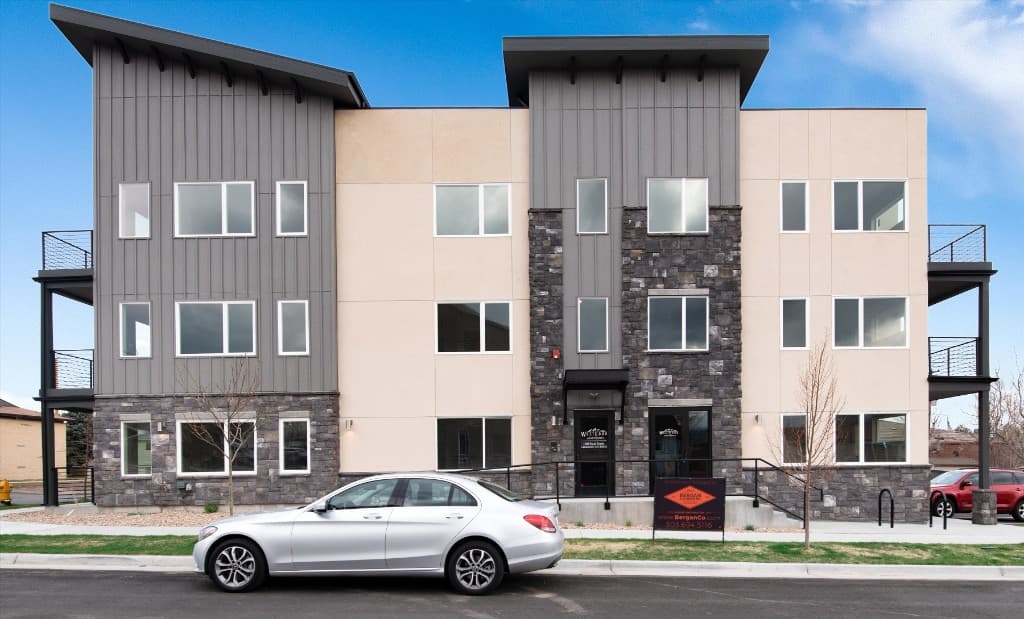 Route Apartments, a three-story modern building with stone, stucco and metal siding and a Bergan & Company leasing sign